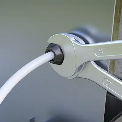 Introduire le câble et serrer l'écrou de pression à l'aide de la clé.