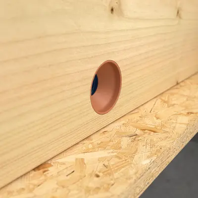 Pull the conduit back through the hole until the junction element is flush with the external surface.