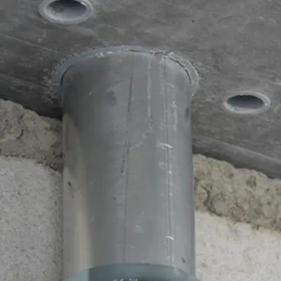 Les tubes apparents M25 sont posés près du mur.