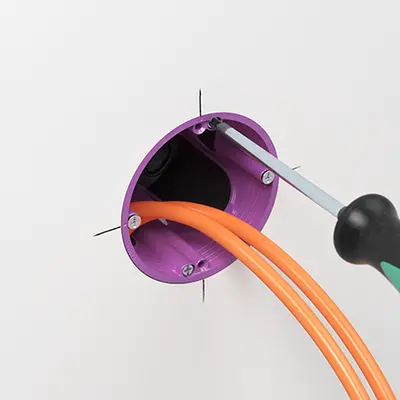 Placer le boîtier de raccordement O-range ECON® Data dans l'orifice d'encastrement, l'aligner selon le marquage central et serrer les vis de pattes.